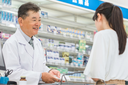 業務改善に取り組む薬局で接遇よく患者対応する薬剤師の様子